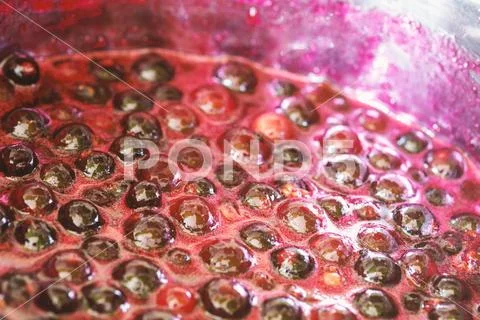 Background with black currant jam boiling in a saucepan Stock Photos
