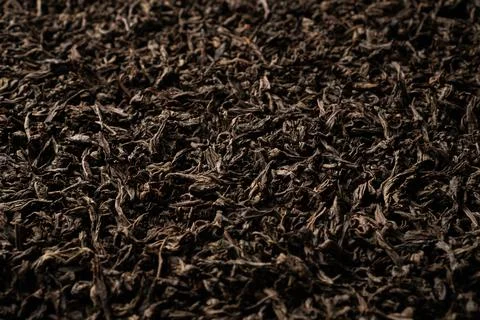 Background of black loose-leaf tea. Close up, angled view. Stock Photos