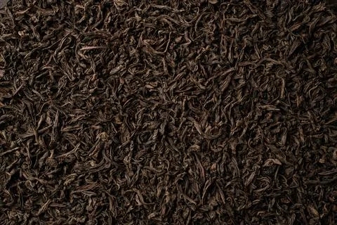 Background of black loose-leaf tea. Close up, top view. Stock Photos