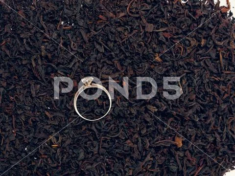 Background of black tea leaves. precious ring. decorations. Stock Photos