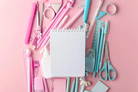 Background with a blank notepad and various pink and blue stationery lying on Stock Photos