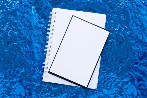 Background of blue crumpled foil. Empty sheet of white paper. Stock Photos