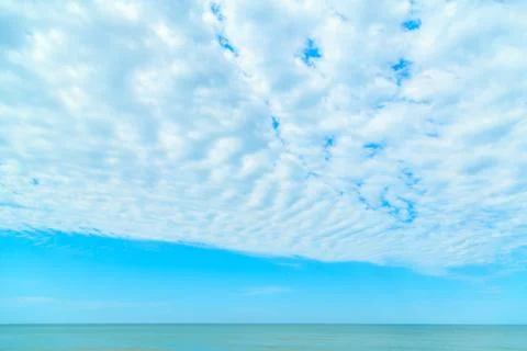 Background of blue sky with beautiful clouds and a small part of the azure se Stock Photos
