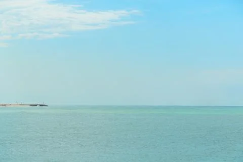 Background of blue sky with beautiful clouds and a small part of the azure se Stock Photos