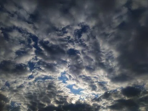 Background of blue sky covered with dark white clouds. Stock Photos