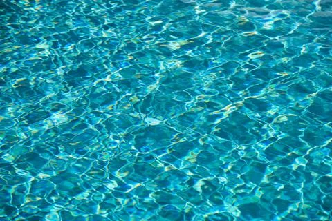 Background of blue water in swimming pool with sun reflection, ripple water wave Stock Photos