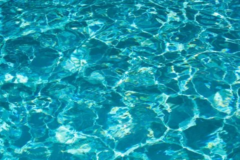 Background of blue water in swimming pool with sun reflection, ripple water wave Stock Photos