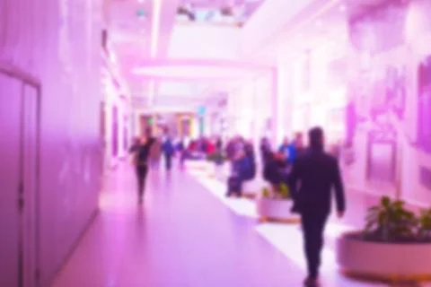 Background blurred image of the lobby in the Mall and shoppers. Toned Stock Photos