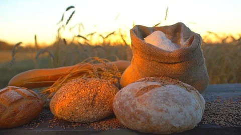 Background of bread, flour, wheat, grains in rustic setting in a wheat field at Stock Footage 97133945