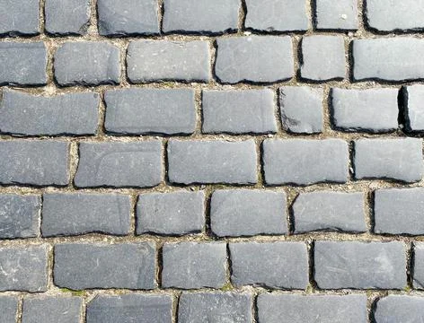 The background of the brick paving slabs is gray. Sidewalk tiles close-up Stock Photos
