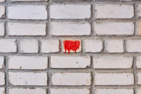 Background from a brick wall of white brick with a red spot in the center. Stock Photos