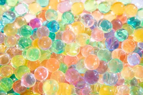 Background of bright multi color transparent gel balls on a sunny day and Stock Photos