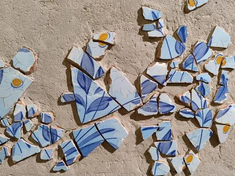 Background of broken traditional ceramic tiles on blue ink mosaic. Stock Photos