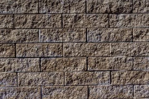 Background of brown-grey stone bricks displayed horizontally in a wall Stock Photos