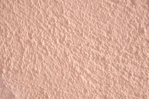 Background with bumps of a salmon-colored wall. Stock Photos