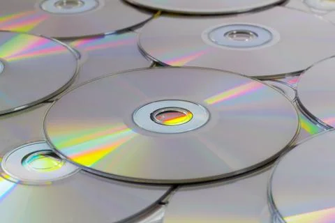 The background of the CDs lying in the heap on the table. Stock Photos