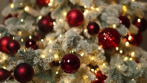 The background is a Christmas tree with white needles, red balls Stock Footage 322945275