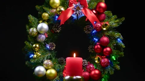 On the background of a Christmas wreath a large candle revolves Stock Footage 166340655