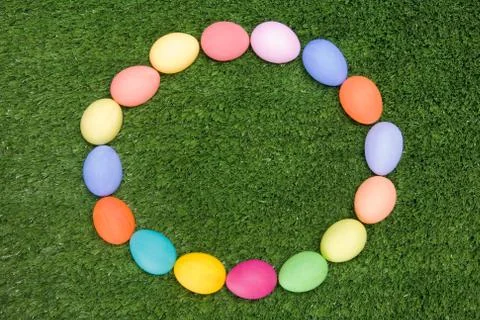 Background of circle made up of colored easter eggs on green grass Stock Photos