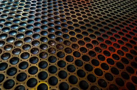 Background of circular holes geometric pattern on a metallic sheet Fotos de archivo