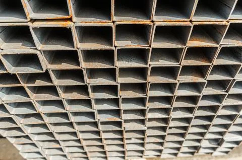 Background close up metal square pipes in stock. Stacks of new square steel Foto stock