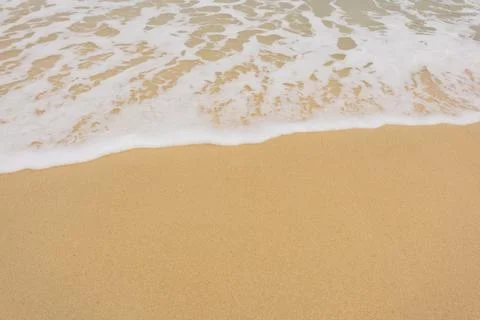 Background close-up of ocean waves rolling on the sand on the beach, with a s Stock Photos
