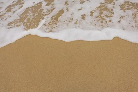 Background close-up of ocean waves rolling on the sand on the beach, with a.. Foto stock