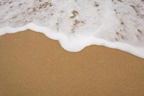 Background close-up of ocean waves rolling on the sand on the beach, with a.. Stock Photos