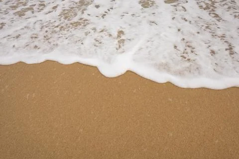 Background close-up of ocean waves rolling on the sand on the beach, with a.. Stock Photos