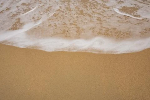 Background close-up of ocean waves rolling on the sand on the beach, with a.. Stock Photos