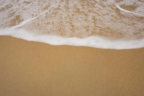 Background close-up of ocean waves rolling on the sand on the beach, with a.. Stock Photos