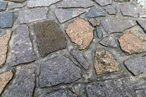 Background cobblestone road close-up. Stone pavement. Stock Photos