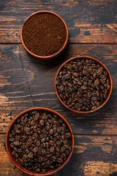Background of coffee beans and grinded ground coffee. Dark wooden background Stock Photos