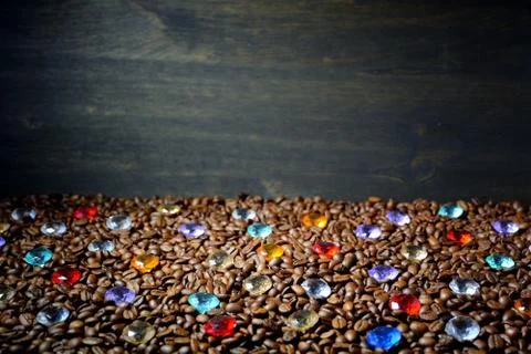 Background from coffee beans with multi-colored stones on a wooden table.2 Stock Photos