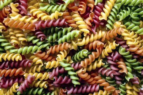 Background of colored noodles. Abstract texture of colorful pasta Stock Photos
