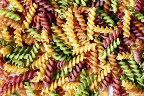 Background of colored noodles. Abstract texture of colorful pasta Stock Photos