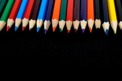 Background from colored pencils on a black surface. Stock Photos