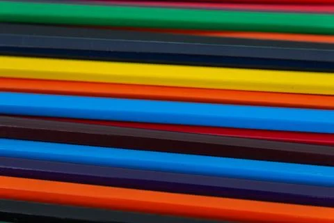Background from colored pencils on a black surface. Stock Photos
