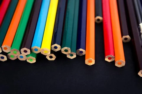Background from colored pencils on a black surface. Stock Photos