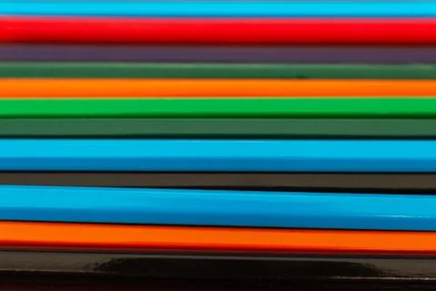 Background from colored pencils on a black surface. Stock Photos