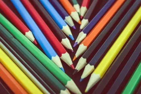 Background from colored pencils on a black surface. Stock Photos