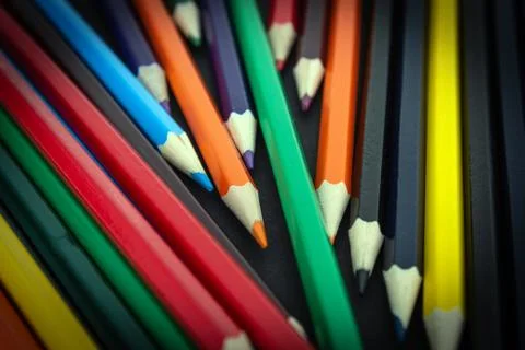 Background from colored pencils on a black surface. Stock Photos