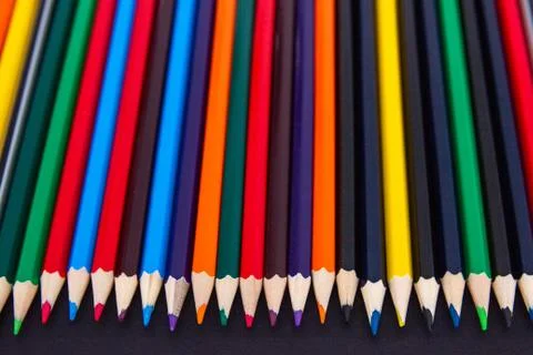 Background from colored pencils on a black surface. Stock Photos