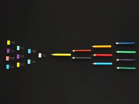 Background colored pencils in three rows against paper clips on black background Stock Photos