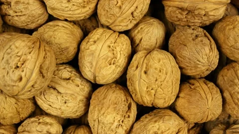 The background is completely filled with nuts. Top view walnuts, dolly shot Vídeos de archivo 181597989