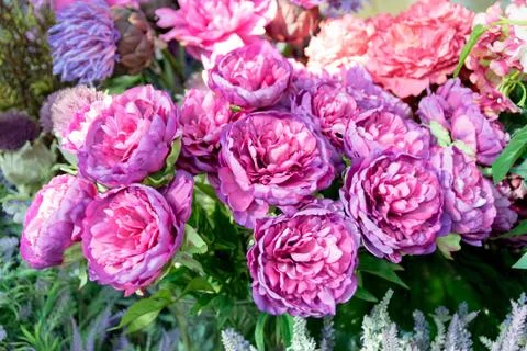 Background consists of artificial flowers. Stock Photos