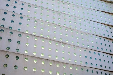 Background created with a concrete structure with holes and green glass. Stockfoto's