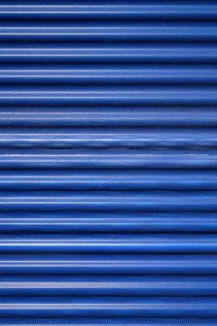 Background created with the foreground of a blue, striated and perforated m.. Stock Photos
