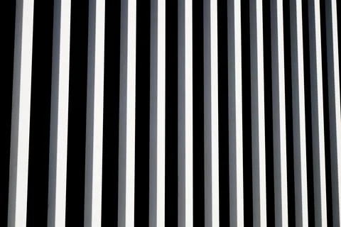 Background created with the foreground of a fence made of vertical square m.. Stock Photos