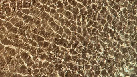 Background of crystal clear water. Close-up of sea water with light reflections. Stock Footage 243457245